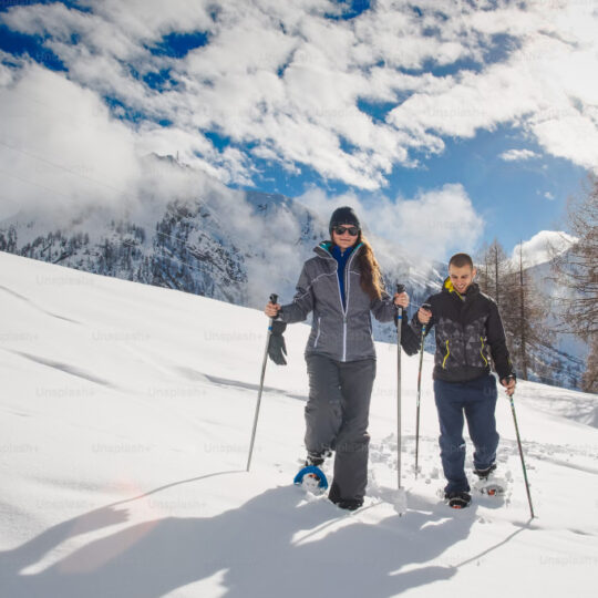 People hiking through snow with snowshoes